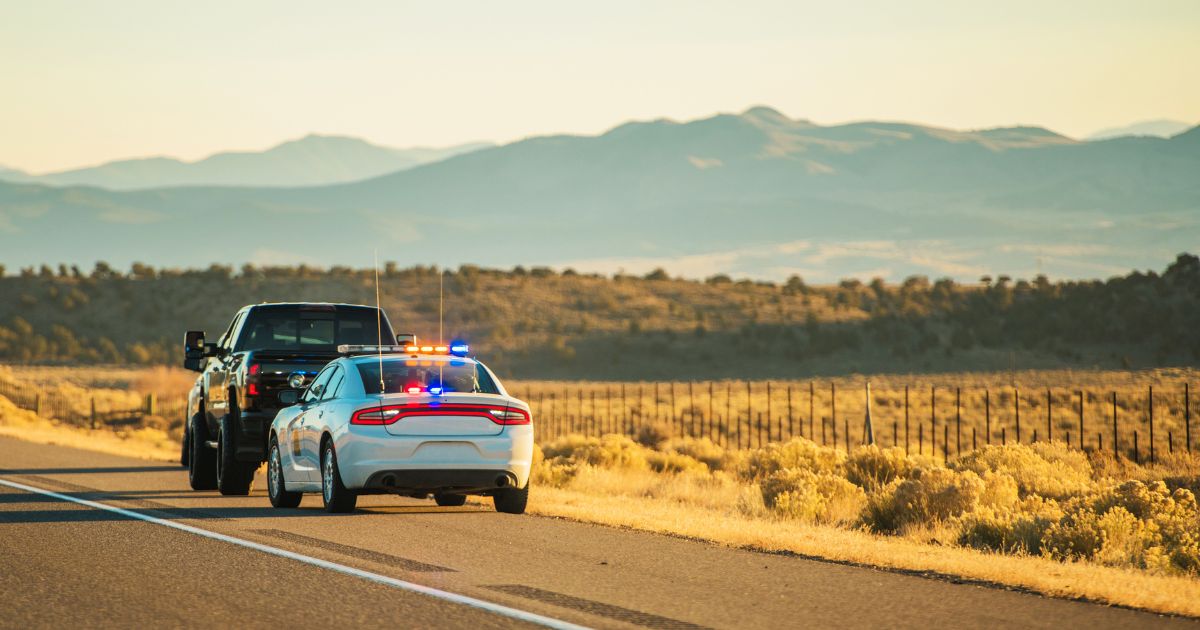 Police car parked behind black SUV on highway